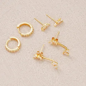 Detailed view of three pairs of gold-plated earrings with clear cubic zirconia accents.