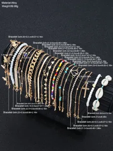 Detailed view of a 22-piece gold anklet set with cross, shell, and bead charms.