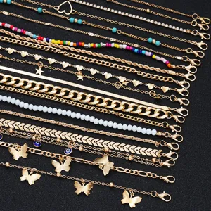 Detailed macro view of a 22-piece gold anklet set featuring butterfly and heart charms