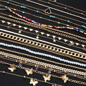 Detailed view of a 22-piece gold anklet set featuring butterfly, star, and heart charms.