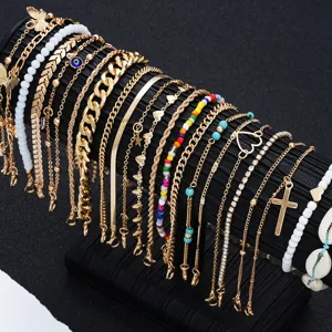 Detailed view of a 22-piece gold anklet set with cross, shell, and colorful bead charms