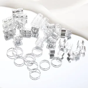 Detailed macro view of silver filigree hair rings and hollow cuffs for DIY braid styling