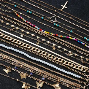Detailed view of a 22-piece gold anklet set featuring cross, butterfly and colorful bead charms
