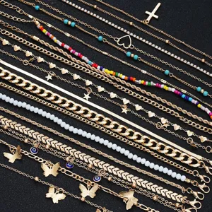 Detailed macro view of a 22-piece gold anklet set with charms like cross, heart and beads
