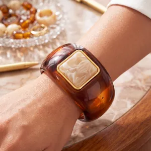 Primer plano de un brazalete de resina de carey con un detalle cuadrado jaspeado