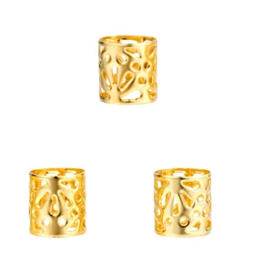 High-definition close-up of three decorative hollowed-out golden dreadlock hair rings