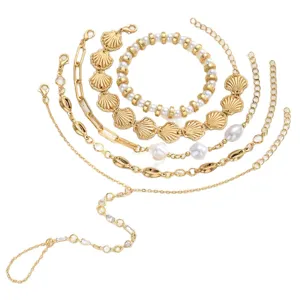 Juego de pulseras bohemias de conchas y perlas con elegante cadena de mano dorada para mujer.