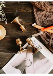 Detailed view of vintage brass-colored aluminum candle holders on a rustic table