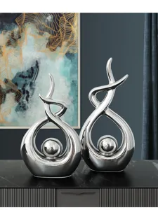 Macro view of silver abstract ceramic sculptures featuring elegant metallic finish
