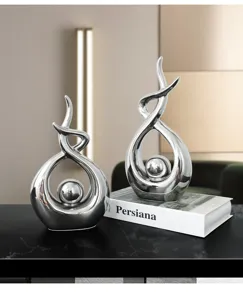 Modern silver abstract sculptures for home decor displayed on a black marble table