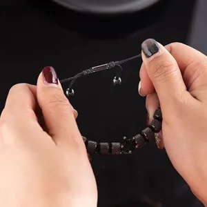 Gros plan détail du bracelet tressé réglable pour homme avec des perles et une couronne.