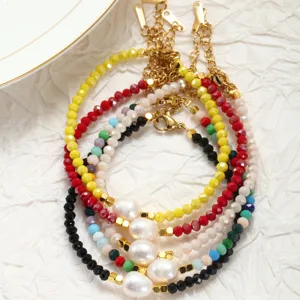 Gedetailleerd overzicht van kleurrijke kristalen kralenarmband met zoetwaterparel en ketting.