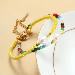 Gedetailleerde close-up van kleurrijke kristal kralen armband met zoetwaterparel en goud.