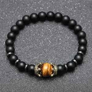Vue détaillée du bracelet de perles noires mates pour hommes avec pierre œil de tigre et couronne.