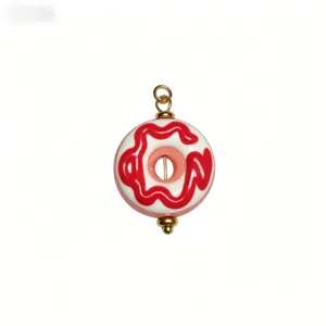 Nahaufnahme Detail des süßen Donut Emaille Anhängers mit roter Glasur für DIY Schmuck.