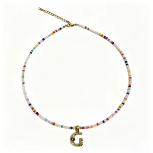 Collana girocollo con perline colorate in stile bohémien e ciondolo con lettera G dorata.