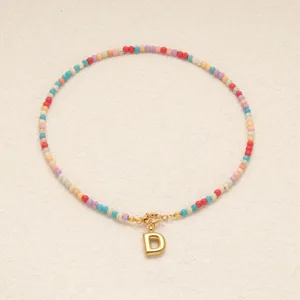 Collier boheme en perles colorees avec pendentif lettre d doree pour accessoire mode