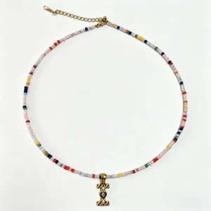 Collana di perle colorate bohémien con ciondolo a lettera dorata, gioielli artigianali donna.