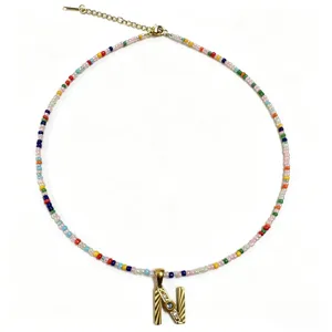 Dettaglio della collana di perline colorate con ciondolo a lettera N color oro chic.