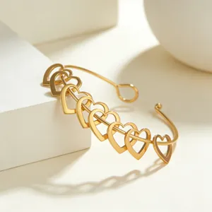 Nahaufnahme Detail des goldenen Edelstahl Herz Manschettenarmbands mit Kettengliedern.