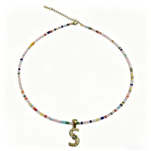 Collana di perline colorate fatta a mano bohémien con dettaglio ciondolo lettera S oro 18K.