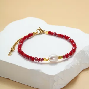 Rode kristalen kralen armband met natuurlijke zoetwaterparel en gouden accenten detail