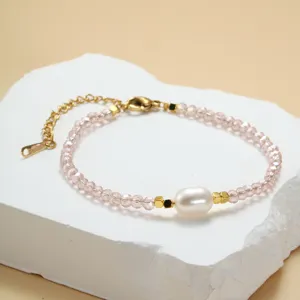Close-up detail van de roze kristal en zoetwaterparel kralen armband met gouden ketting.