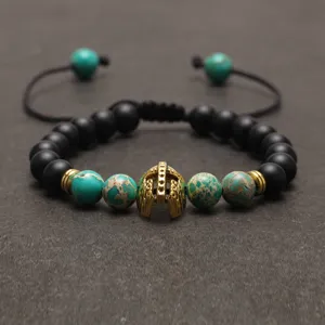 Türkis und schwarzer Lavastein geflochtenes Armband mit goldenem Spartanerhelm Anhänger.