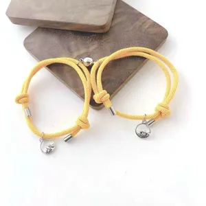 Vue détaillée de bracelets de couple tressés jaunes magnétiques avec pendentifs de montagne.