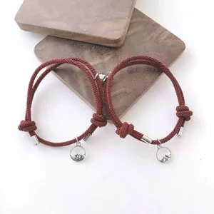Gros plan de bracelets de couple magnétiques tressés avec pendentifs vague et montagne.