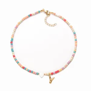 Nahaufnahme der bunten Perlenkette mit goldenem Buchstaben Y und Herzanhänger im Boho-Stil.