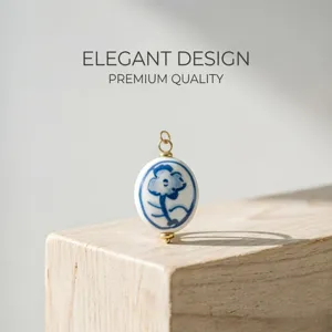 Nahaufnahme eines handbemalten blau-weißen Keramikblumen-Anhängers für DIY-Schmuck.