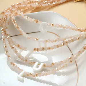 Détail en gros plan du collier multi-rangs perles coquillage lettre bijou bohème.