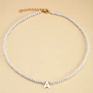 Gros plan detaille du collier de perles elegant avec un charmant pendentif lettre A blanc.