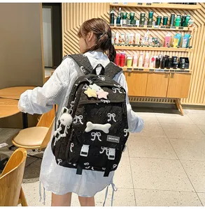 Mochila acolchada negra con bordados de lazos blancos y colgantes de estrellas suaves