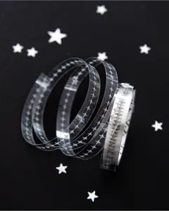 Gros plan d'un ruban adhésif transparent avec motif d'étoiles noires pour journaux
