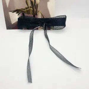 Vue détaillée d'une pince à cheveux nœud noir doux avec de longs rubans élégants