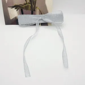 Détail montrant la texture en maille argentée scintillante de cette élégante barrette à nœud
