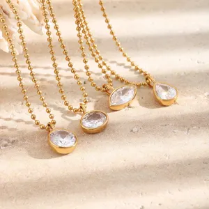 Close-up view of elegant teardrop and oval shaped zircon pendants on gold beaded chains