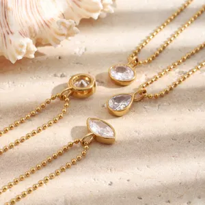 Detail of 18K gold plated stainless steel necklaces with sparkling crystal pendants