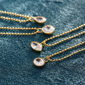 Detailed shot of gold beaded necklaces featuring sparkling clear zircon pendants