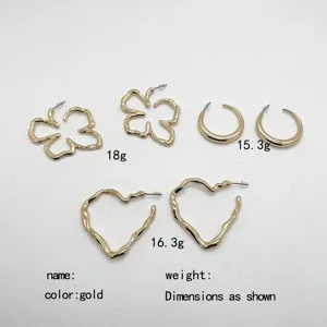 Set of three exaggerated gold geometric earrings including flower and heart shapes