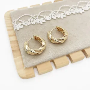 Close-up of elegant gold twisted hoop earrings with a minimalist geometric design