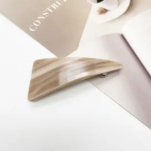 Detail of minimalist resin hair clip with elegant brown marble texture finish