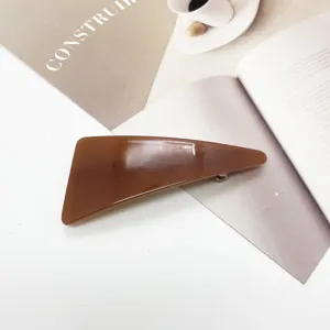 Macro detail showing the smooth texture of a minimalist brown resin geometric hair clip