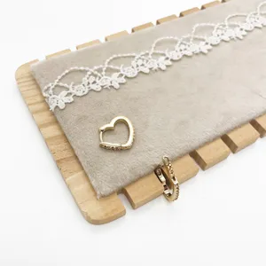 Close-up of gold heart-shaped hoop earrings with encrusted details on display pad.