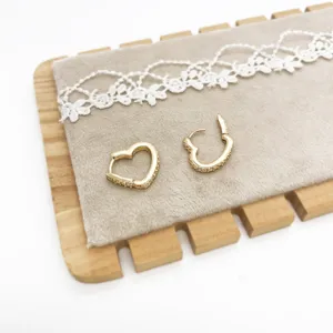 Detail shot of elegant gold heart-shaped hoop earrings with sparkling rhinestones