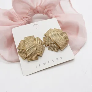 Macro detail of retro golden geometric stud earrings with woven texture pattern