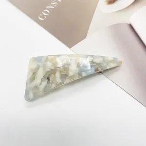 Close-up macro view of minimalist triangular resin hair clip with blue marble pattern