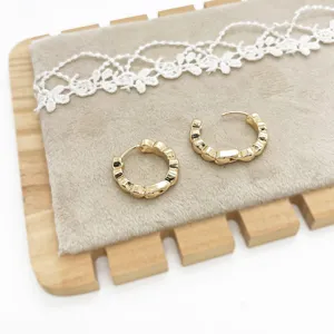 Detail shot of minimalist gold-finished geometric hoop earrings with textured ridged design